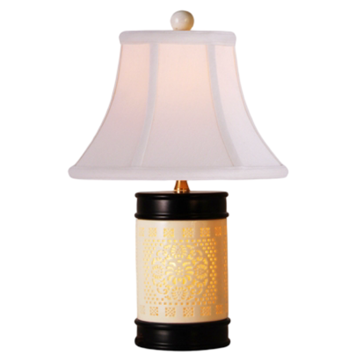 Table lamp with white shade and decorative base on a white background