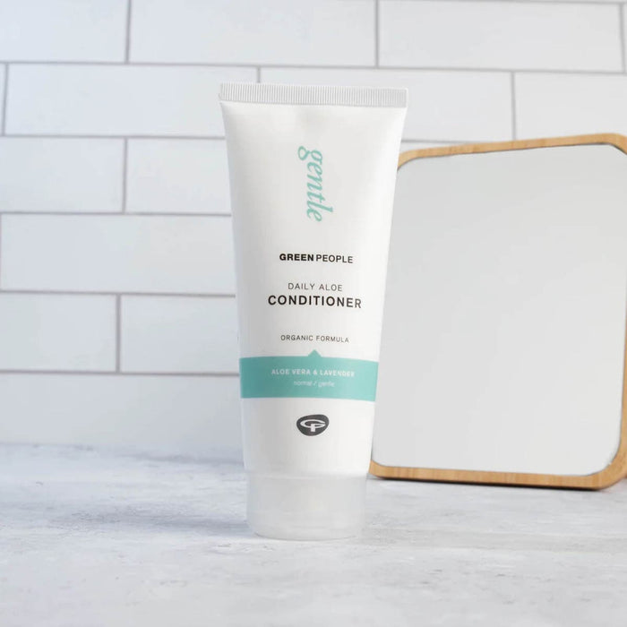 Green People daily aloe conditioner bottle on a bathroom counter with a mirror in the background