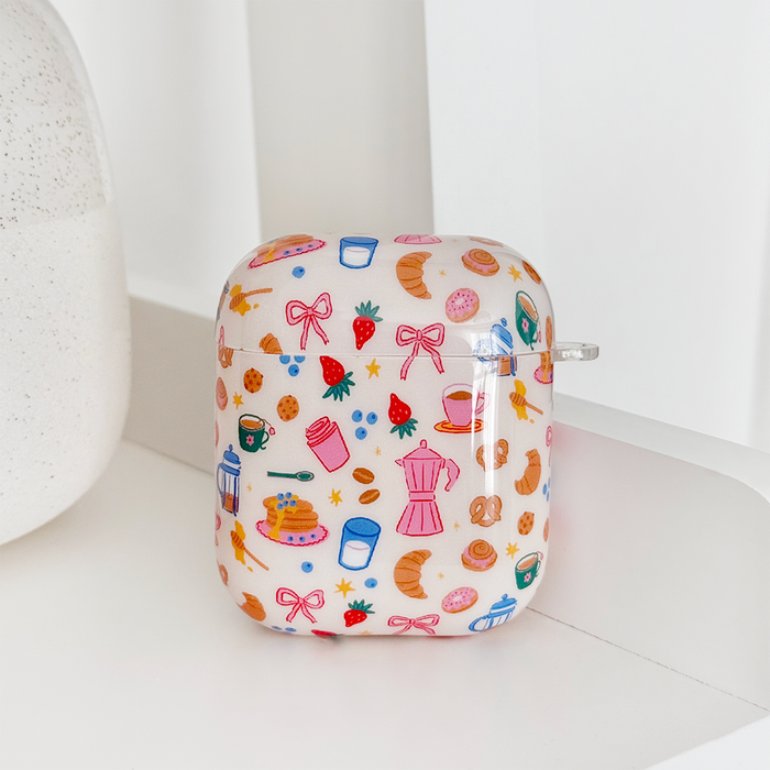 Coconut Lane AirPods case with a white background, decorated with croissants and coffee cup illustrations.