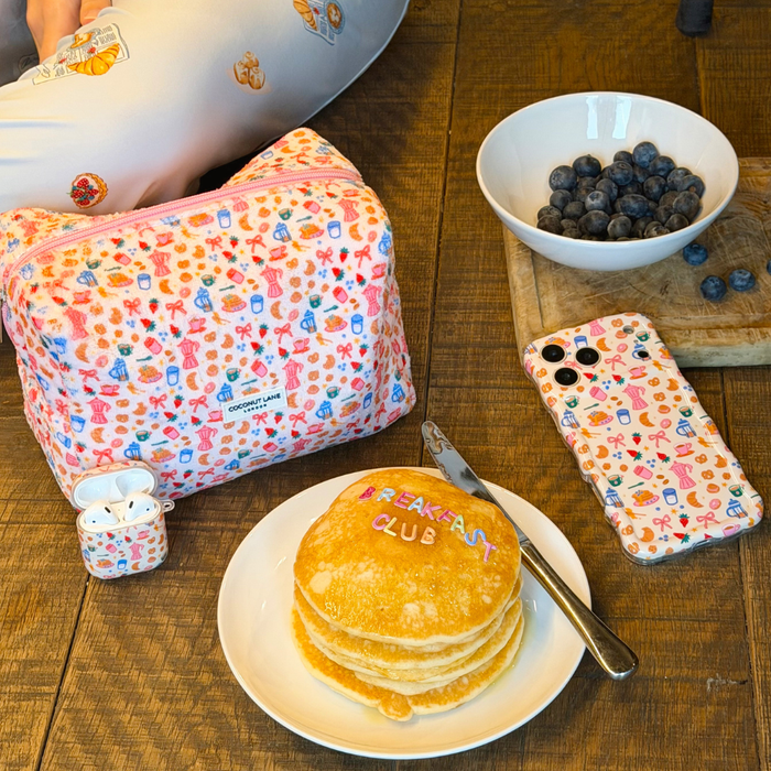 Coconut Lane Airpods case with pancake stack design, white icing, blueberries, and a silver keychain attachment.