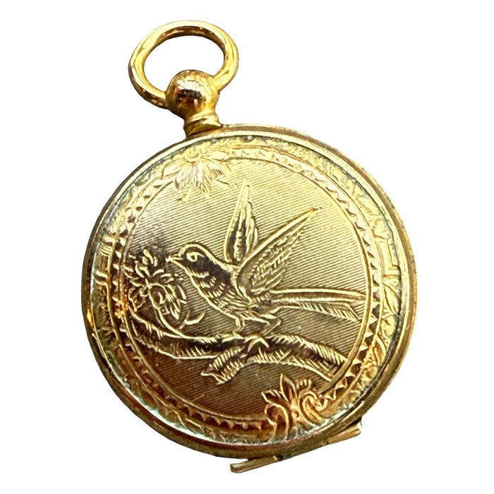 Gold pocket watch with bird engraving on a white background
