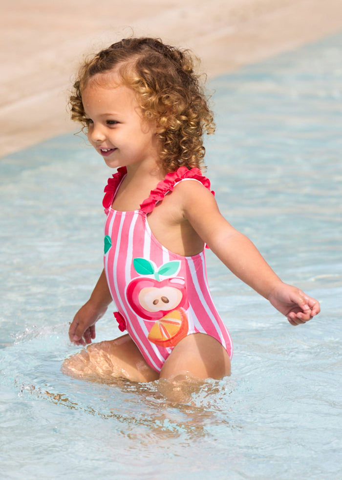 Baby girl wearing Mayoral Pink graphic swimsuit for pool and summer water play.
