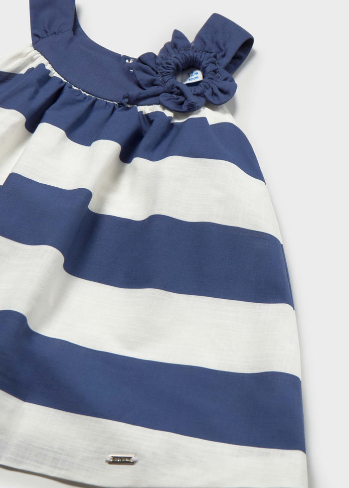 Closeup of Mayoral baby girl cotton dress showing Navy/White stripes and decorative flower detail.