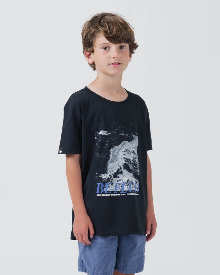Kingz Be Fluid Youth Tee Black - Front View Young Male Model Ocean Wave Graphic BE FLUID Text Short Sleeve Casual Fit Streetwear [color:Black]