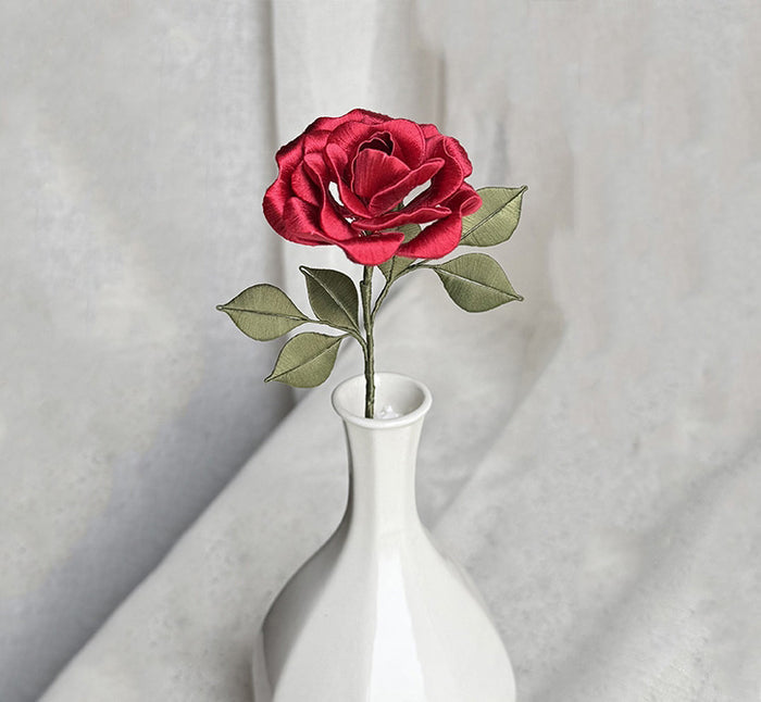 Finished red blooming rose handcrafted from DIY kit, displayed in a white vase.