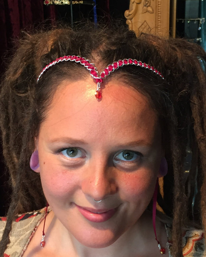 model wearing silver wire braided ribbon crown with red ribbon and crystal drop, front view