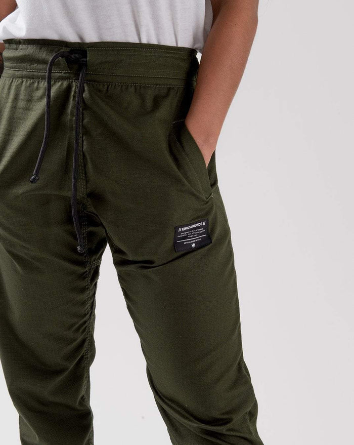 Kingz Casual Rip Stop Gi Pant Military Green - Close-Up Front View Male Athlete Black Drawstring Waist Kingz Logo Patch Right Thigh Durable Rip Stop Fabric BJJ Gi Training [color:Military Green]