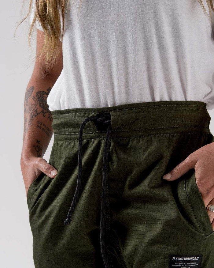 Kingz Casual Rip Stop Gi Pant Military Green - Close-Up Waist View Female Athlete Military Green Rip Stop Fabric Black Drawstring Kingz Kimonos Patch Front Pocket BJJ Gi Training [color:Military Green]