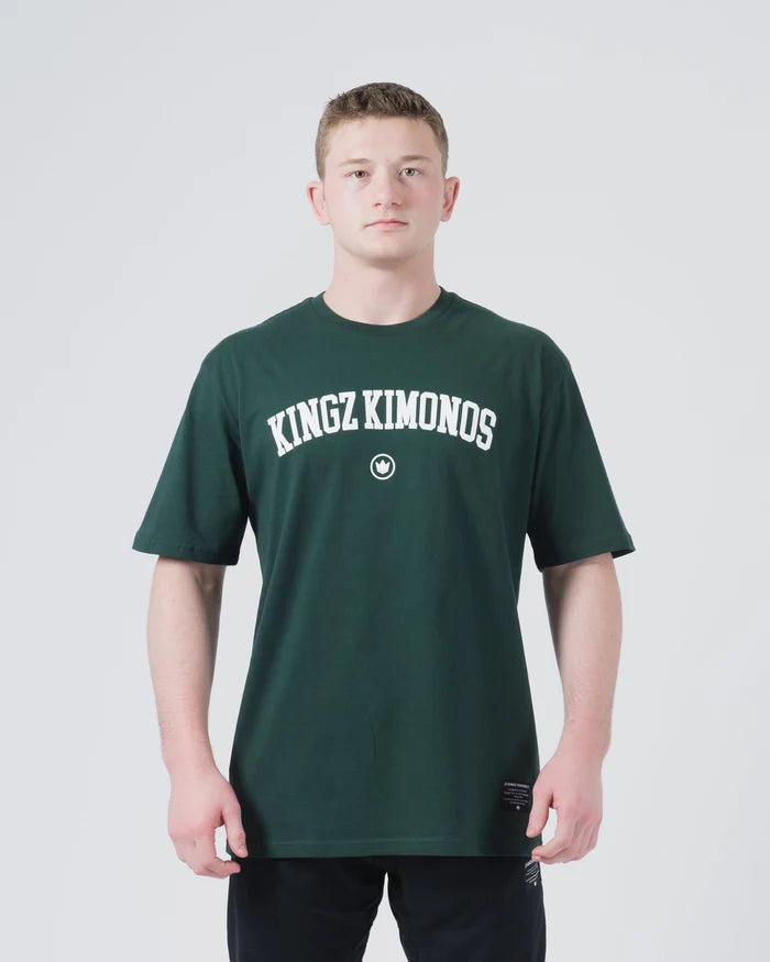 Kingz Collegiate Tee Dark Forest Green - Front View Male Athlete KINGZ KIMONOS Arched White Text Center Crown Badge Below Short Sleeve Relaxed Fit BJJ Training Apparel [color:Dark Forest Green]