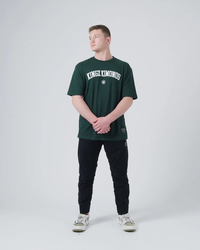 Kingz Collegiate Tee Dark Forest Green - Full Body Front View Male Athlete KINGZ KIMONOS White Text Center Chest Relaxed Fit BJJ Training Apparel [color:Dark Forest Green]