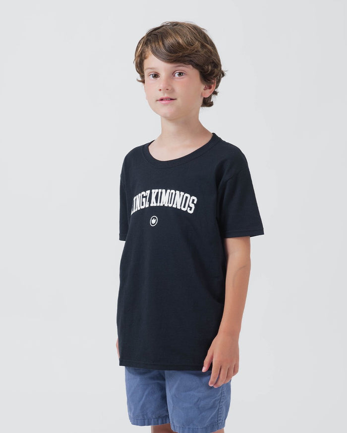 Kingz Collegiate Youth Tee Black - Front View Young Male Model Black Tee White KINGZ KIMONOS Arched Text Center Chest Casual Fit Streetwear [color:Black]