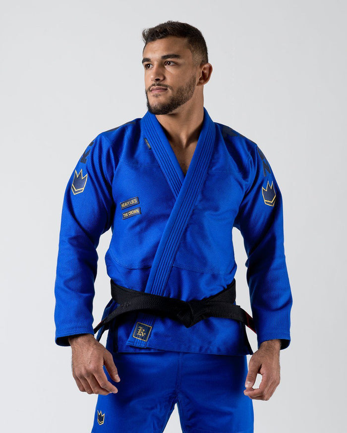 Kingz Comp 450 V6 Gi Blue - Front View Male Athlete Blue Gi Gold Crown Shoulder Patches Black Belt Embroidered Text Chest Durable Weave Fabric Jiu Jitsu Gear Training Gi [color:Blue]