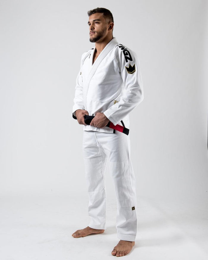 Kingz Comp 450 V6 Gi - White - Three Quarter View Male Athlete Black Shoulder Text Gold Crown Badge Black Belt White Fabric Durable Design BJJ Jiu Jitsu Gear [color:White]