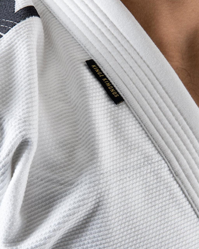 Kingz Comp 450 V6 Gi - White - Close-Up Detail View Woven Texture Black Kingz Kimonos Tag White Collar Durable Fabric Jiu Jitsu Gear [color:White]