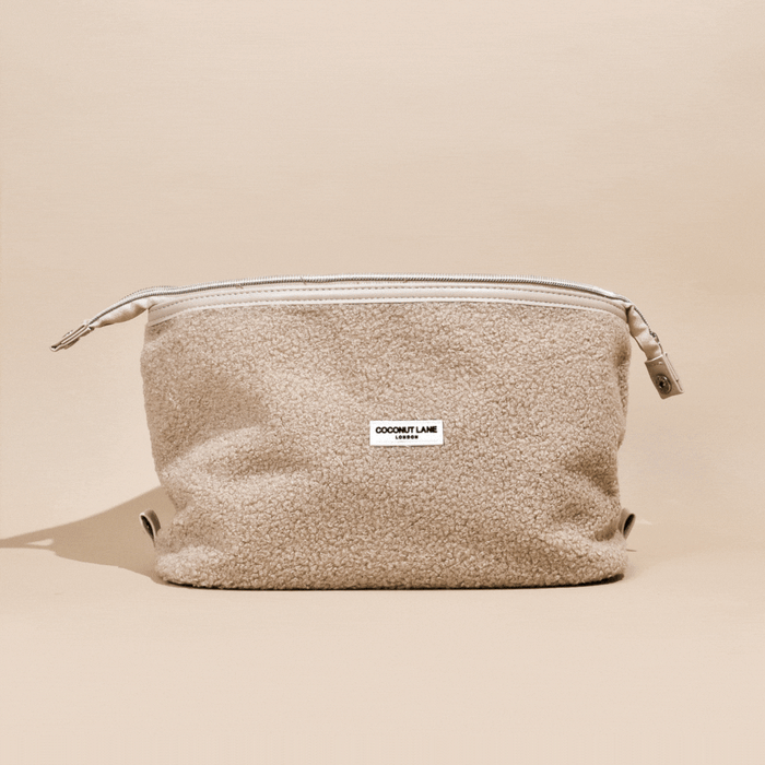 Beige expandable makeup bag with Teddy Rupert design by Coconut Lane, shown on a matching beige background.