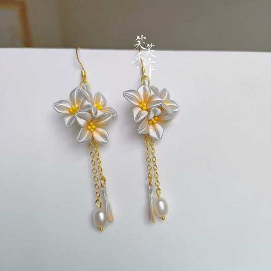 Handcrafted Chanhua floral dangle earrings in sky blue with 925 silver hooks and natural freshwater pearls, side view.
