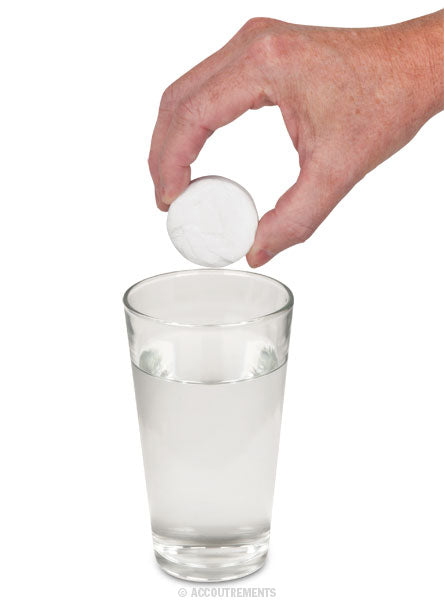 A hand is dropping a large tablet into a glass of water, reminiscent of how Instant Underpants expand when soaked.