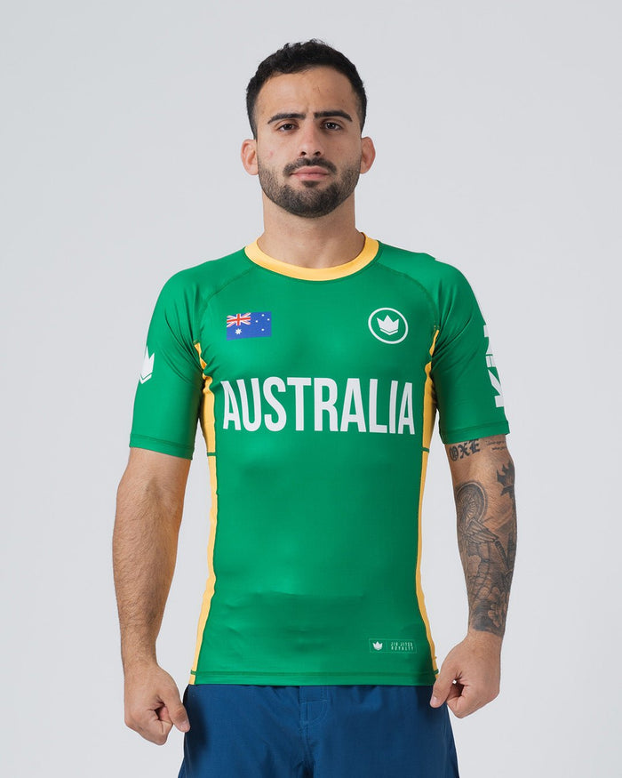 Kingz Jersey Rashguard Australia Edition - Full Body Front View Male Athlete Short Sleeve Green Body AUSTRALIA White Bold Text Australian Flag Patch White Crown Logo Yellow Gold Collar Yellow Side Stripes BJJ National Pride MMA [color:Green/Austria]