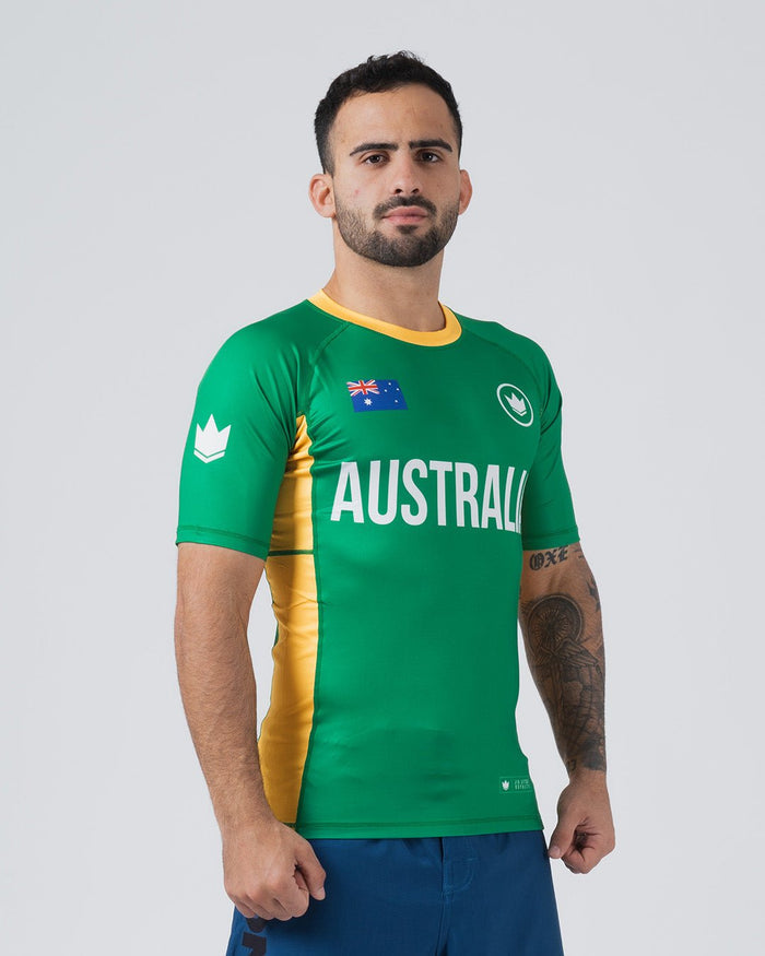 Kingz Jersey Rashguard Australia Edition - Full Body Front Right Side View Male Athlete Short Sleeve Green AUSTRALIA Bold Text Australian Flag Crown Logo Yellow Gold Right Side Stripe Visible BJJ MMA National Pride [color:Green/Austria]