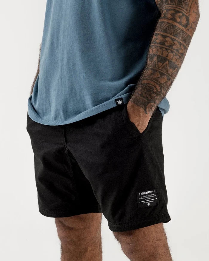 Kingz Casual Gi Shorts Black - Front View Male Athlete Black Shorts White Label Text Right Leg Crown Logo Comfortable Fit BJJ Grappling Training [color:Black]