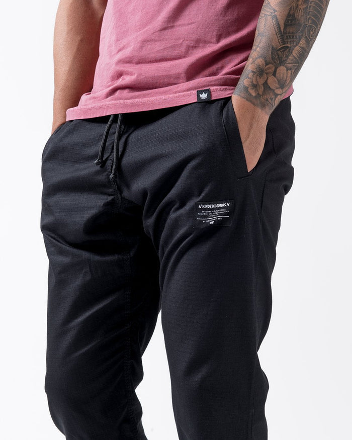 Kingz Casual Rip Stop Gi Pant - Black - Close-Up Front View Male Athlete Black Rip Stop Fabric Kingz Logo Patch Waistband Drawstring BJJ Training Gi [color:Black]