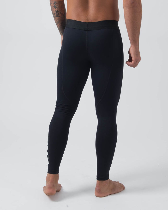 Kingz Kore Grappling Spats Black - Full Body Right-Back Side Profile Shirtless Tattooed Male Athlete All-Black KINGZ White Vertical Text Right Calf Men's No-Gi BJJ Spats Kore Collection [color:Black]