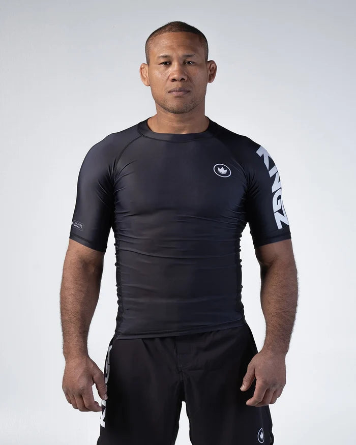 Kingz Kore V2 Short Sleeve Rashguard Black - Full Body Front View Male Athlete Black Crown Logo Chest White KINGZ Text Sleeve Sleek Fit BJJ No-Gi Grappling Rash Guard [color:Black]