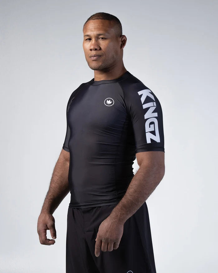 Kingz Kore V2 Short Sleeve Rashguard Black - Front View Male Athlete Black Crown Badge Chest Large KINGZ Text Sleeve Snug Fit BJJ Training Rash Guard [color:Black]