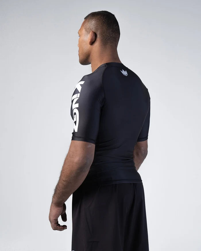 Kingz Kore V2 Short Sleeve Rashguard Black - Back View Male Athlete White KINGZ Text Sleeve Crown Badge Upper Back Fitted Design BJJ No-Gi Grappling Rash Guard [color:Black]