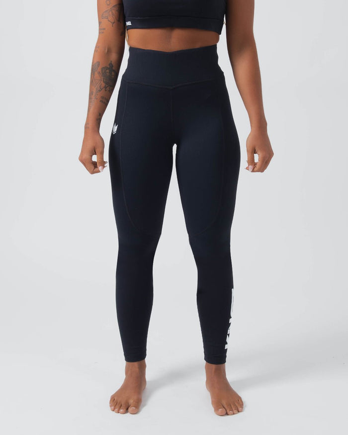 Kingz Kore Women's Grappling Spats Black - Full Body Front View Tattooed Female Athlete All-Black High-Waist Wide Waistband Small White Crown Logo Left Thigh Full-Length Compression Fit Bare Feet Women's No-Gi BJJ Spats Kore Collection [color:Black]