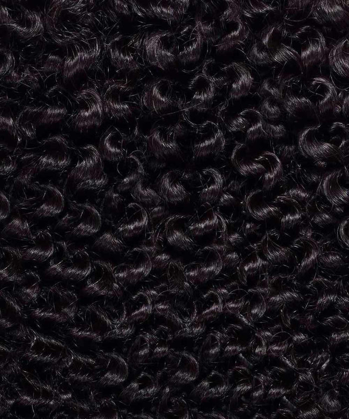 Close-up view of tightly coiled, dark curly hair, with dense, shiny ringlets highlighting natural texture and volume.