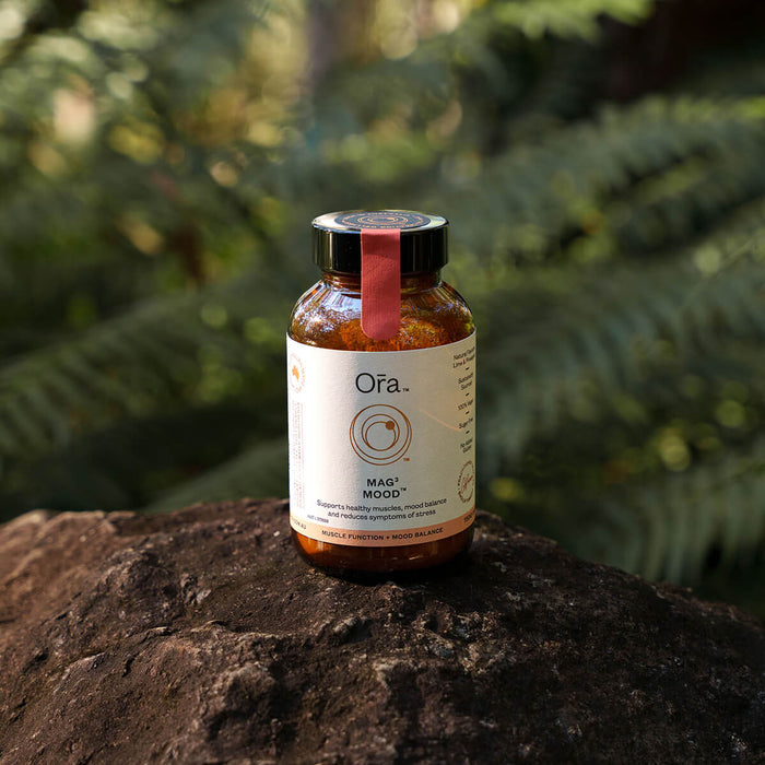 150g jar Ora Mag3 Mood placed on a rock, vegan supplement to support muscles, mood balance, and reduce symptoms of stress.