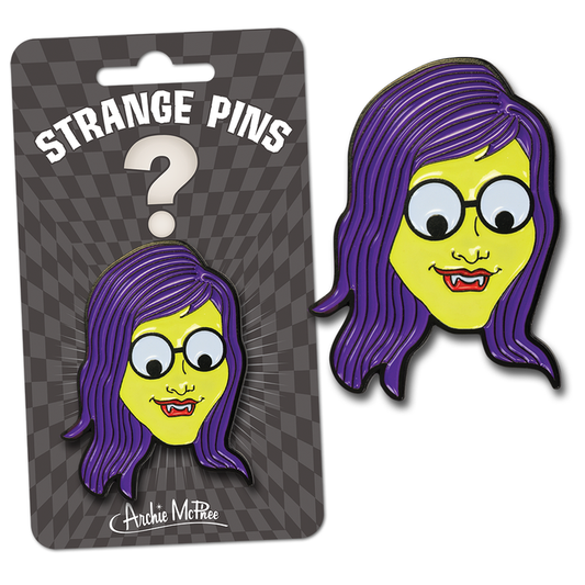 The Monster Girl Strange Pin features a cartoon face with purple hair, a fanged smile, and glasses on packaging labeled "Strange Pins." It is made from enamel and diecast metal for durability.