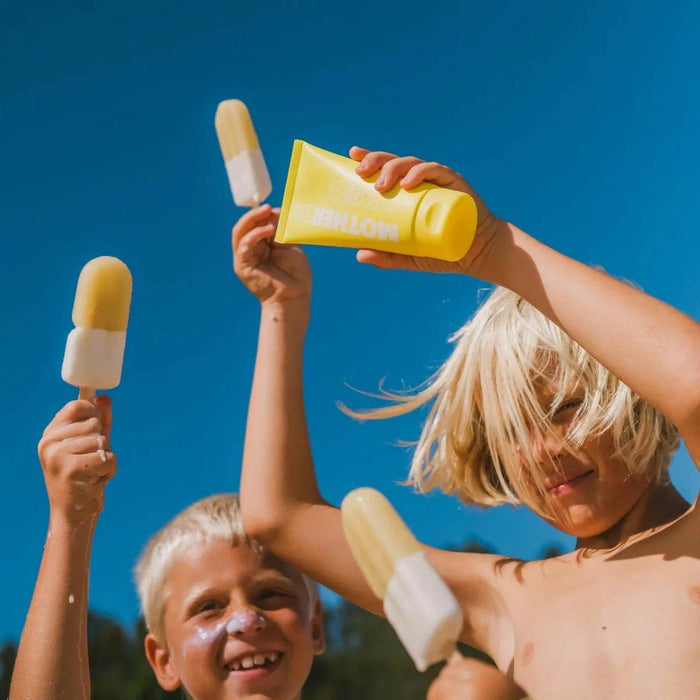 Two children enjoying ice cream and sunscreen on a sunny day.