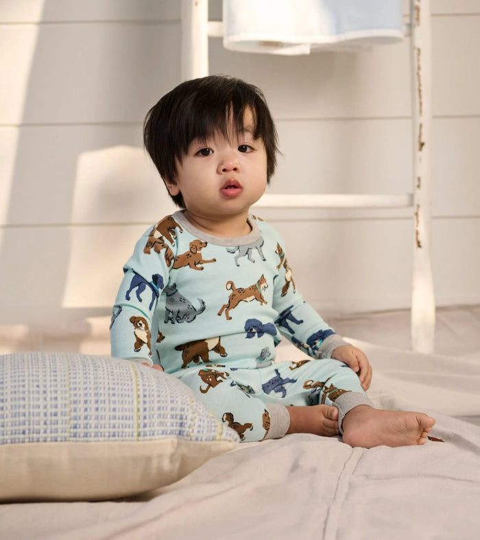 Baby boy wearing Hatley Playful Puppies pajamas with soft organic cotton and snap shoulder comfort.