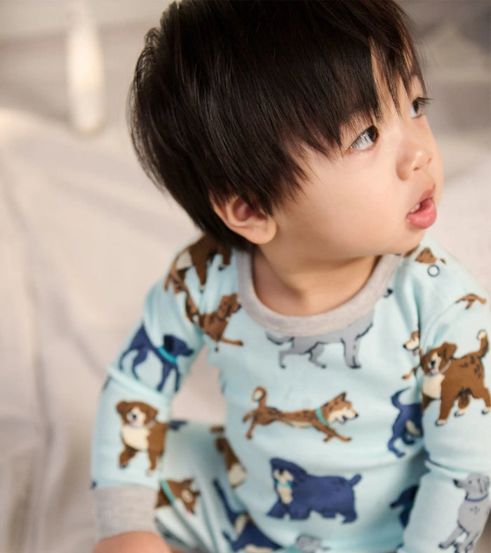Closeup of baby boy in Hatley Playful Puppies pajama top with dog print and soft cotton fabric.
