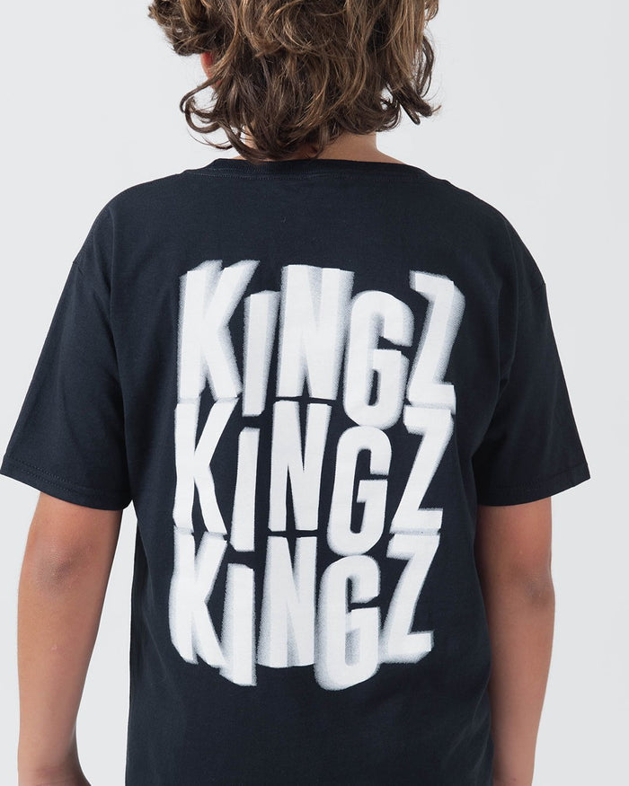 Kingz Quake Youth Tee Black - Back View Youth Model Bold White KINGZ Repeated Text Back Short Sleeve Casual Fit Streetwear [color:Black]