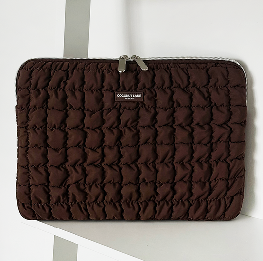 Quilted chocolate brown laptop sleeve with zipper, from Coconut Lane, displayed on a white shelf.