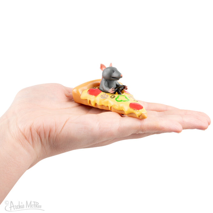 A hand holds a Rat Racers toy rat on a pizza-rocket slice, eager for the rodent-powered racing adventure.