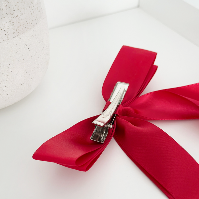 Rose red ribbon bow hair clip with a metal clasp, featuring a soft, elegant finish.