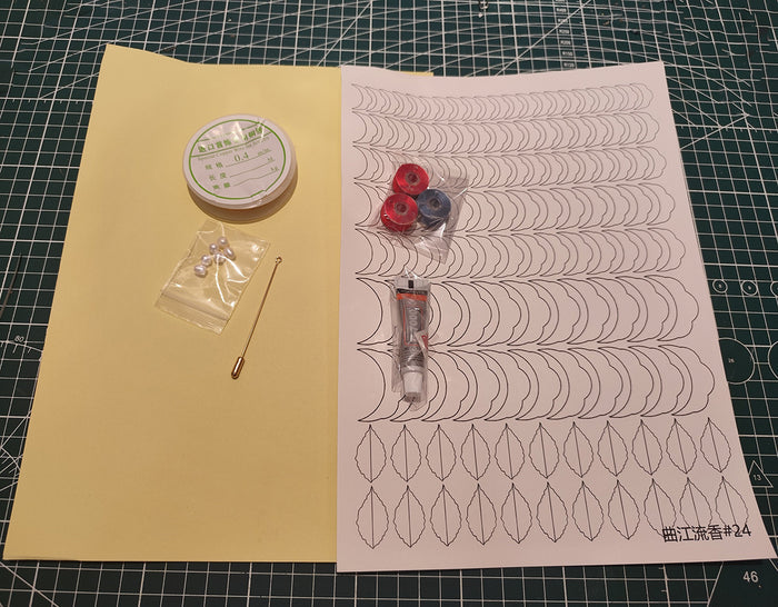 Contents of the Rose Brooch Chanhua DIY Kit, including spools of thread, pearls, a pin base, and templates for creating the flower.