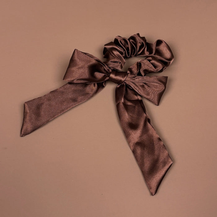 Chocolate brown satin scrunchie with a large bow and long, flowing ribbon tails.