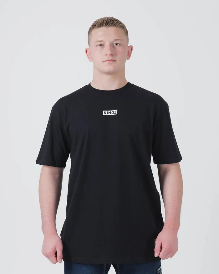 Kingz Slant Bar Tee Black - Front View Male Athlete KINGZ Logo Center Chest Solid Black Short Sleeve Casual Fit BJJ Training T-Shirt [color:Black]