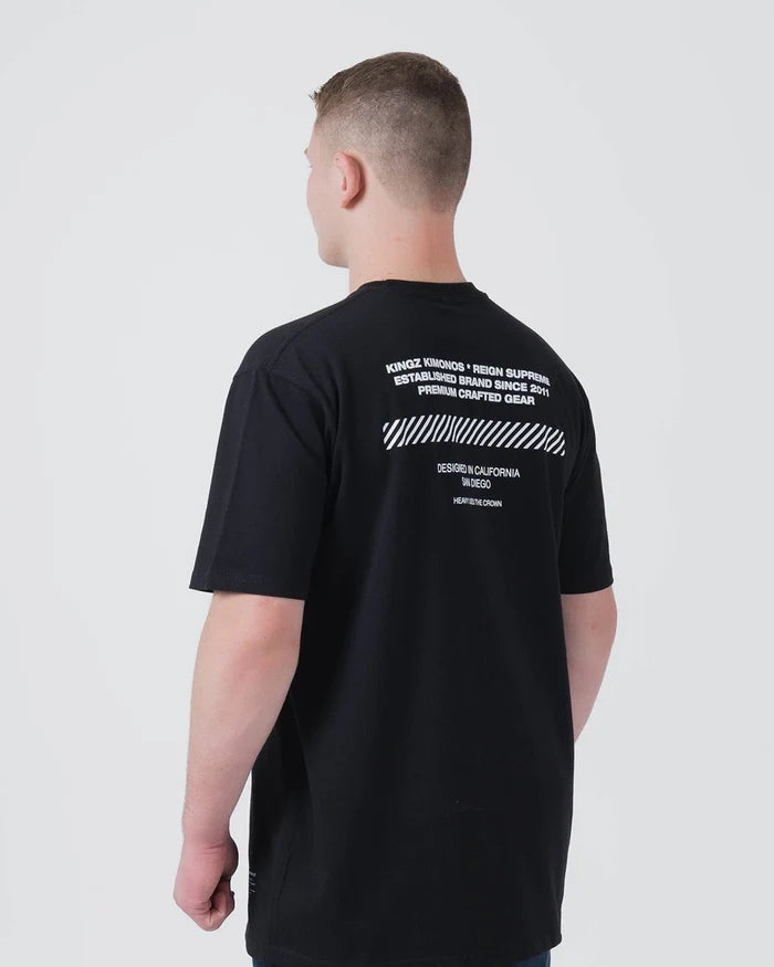 Kingz Slant Bar Tee Black - Back View Male Model White Text Back Upper Panel Diagonal Stripe Design Relaxed Fit Short Sleeve BJJ Training Apparel [color:Black]