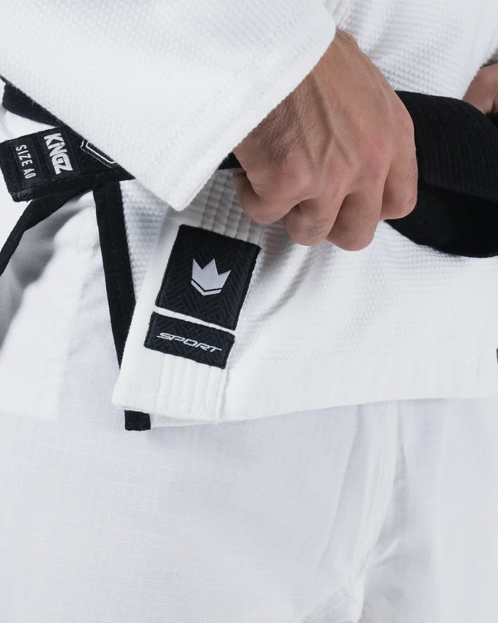 Kingz Sport Jiu Jitsu Gi White - Close-Up Detail View Hand Adjusting Black Belt Crown Badge Black Label White Fabric Texture BJJ Gi Training [color:White]