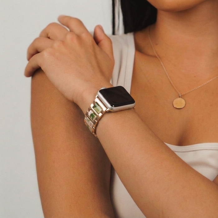 Girl wearing pink, green and rose gold watch strap on her wrist studio shoot