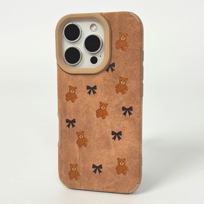White faux suede phone case with teddy bear and black bow pattern.