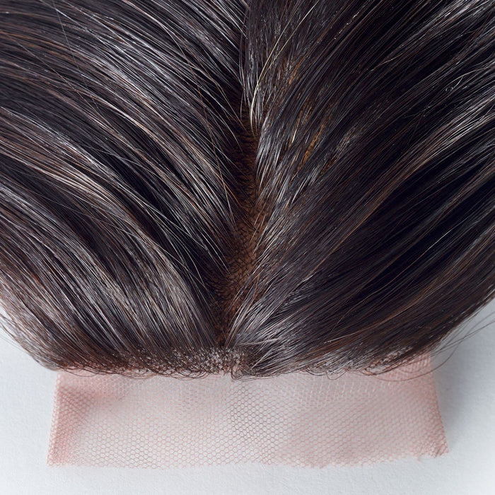 Close-up of a lace hair closure with straight, dark brown human hair parted in the middle, highlighting fine lace and natural hairline.