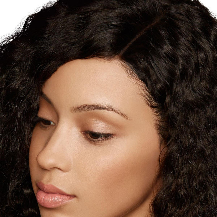 A close-up shows a woman with wavy, dark hair and natural makeup, looking downward calmly. The scene exudes tranquility and elegance.
