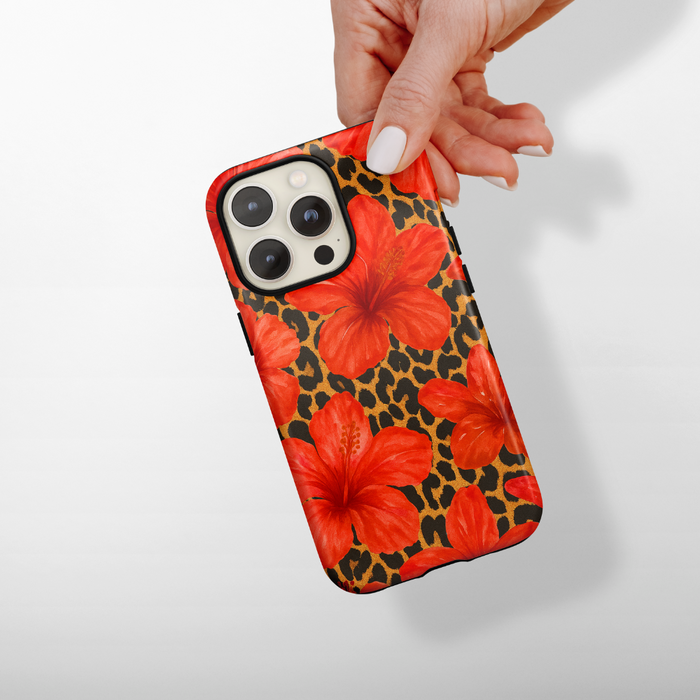Hand holding Coconut Lane Tough MagSafe® Phone Case with a leopard and hibiscus floral pattern.